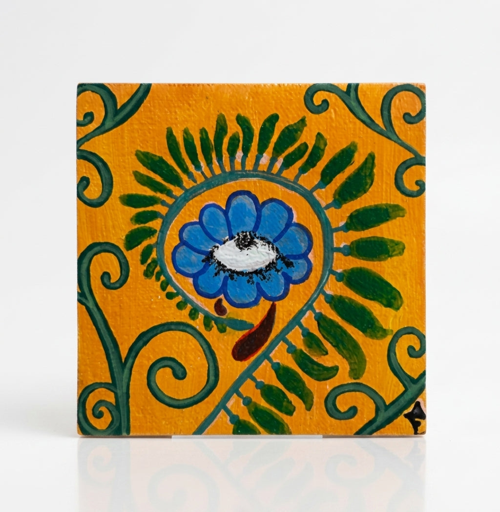 Angelika Faith, Mixed Media on Canvas, Micra flower, yellow, blue. Each print shows a colorful surreal floral illustration with a face and a caption: "WHAT IT KEPT ALIVE," "TEARS OF METAMORPHOSIS," "STILL, SHE BLOOMS," and "A CYCLE THAT GROWS.